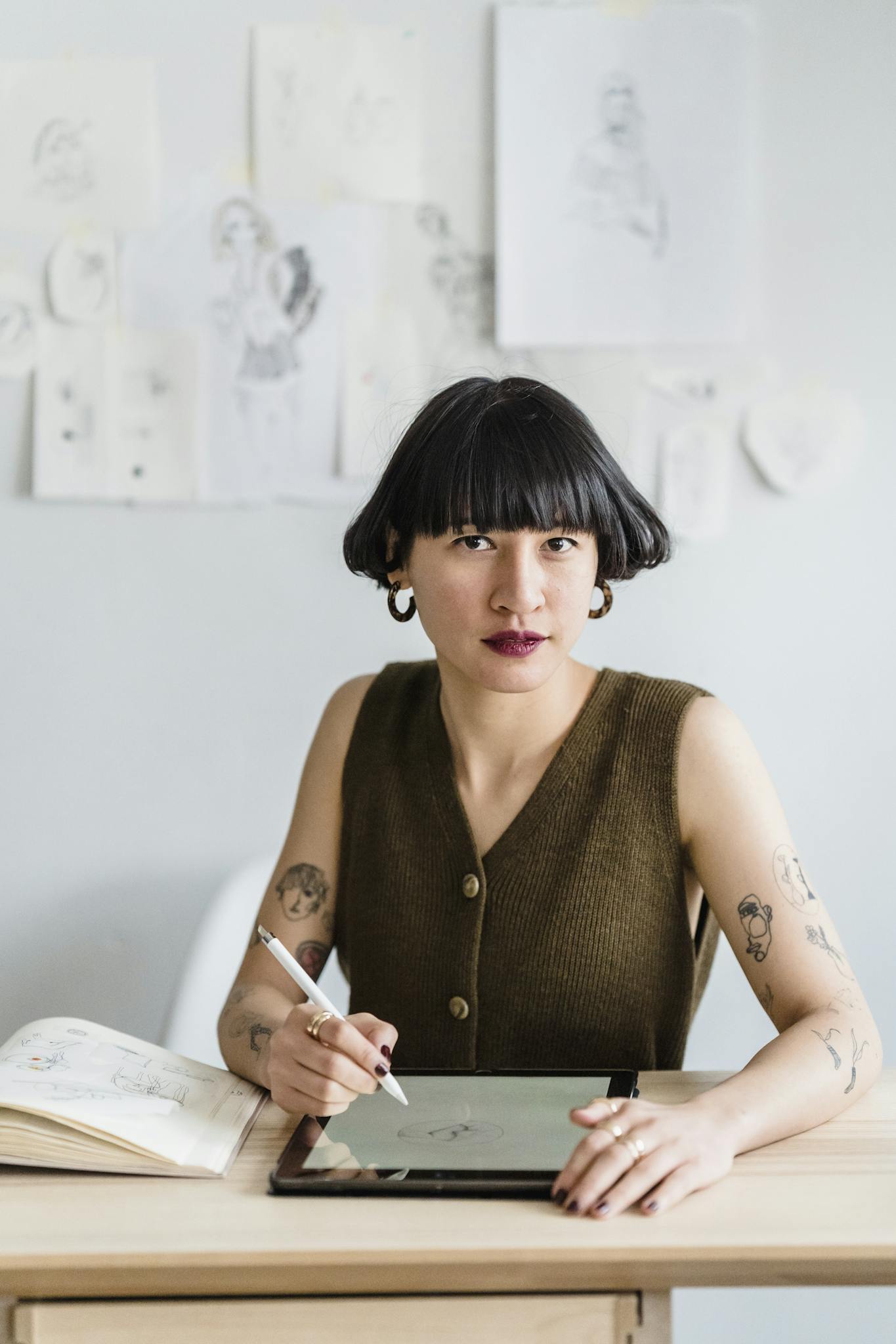 Ethnic woman sitting at table with graphics tablet